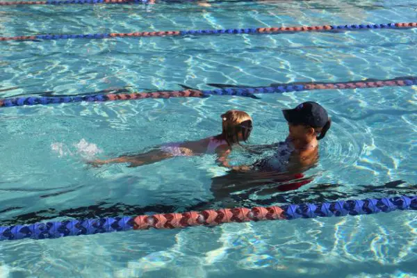 A woman teaching a kid how to swim