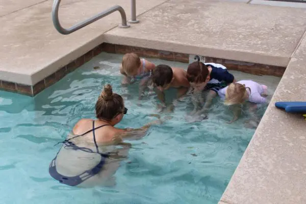 A swimming instructor teaching kids how to breathe underwater
