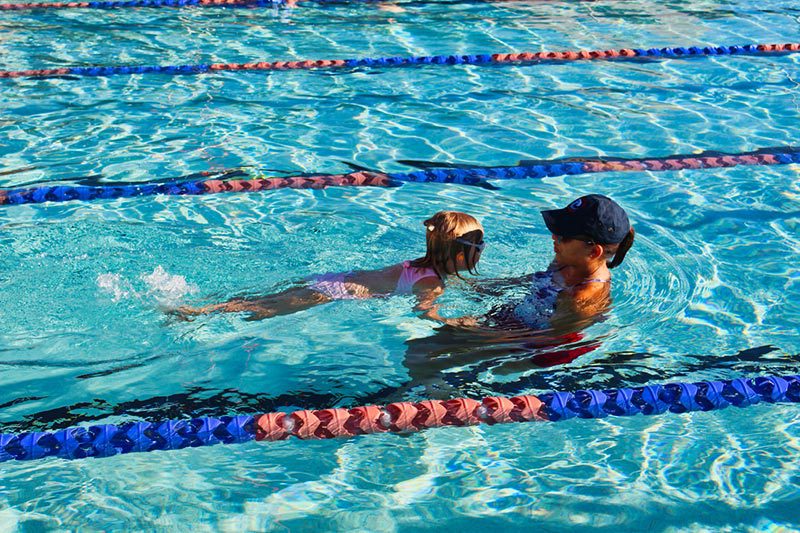 A swimming instructor with her student