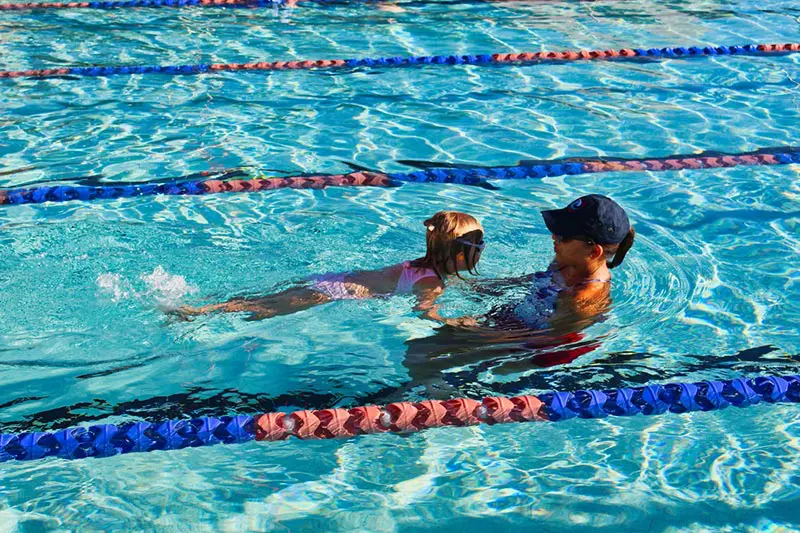 A swimming instructor with her student