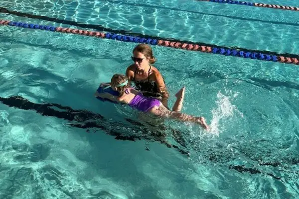 A woman teaching a girl how to swim