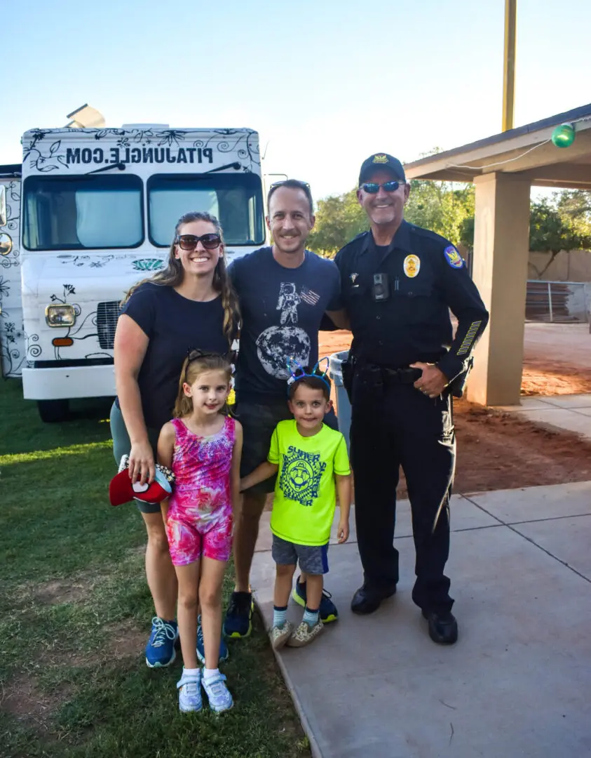 a family of four posing with a police officer